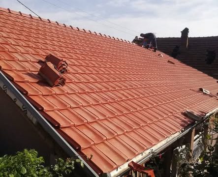 Majstori postavljaju crep na krov kuće – završni građevinski radovi
