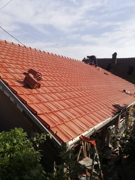 Majstori postavljaju crep na krov kuće – završni građevinski radovi